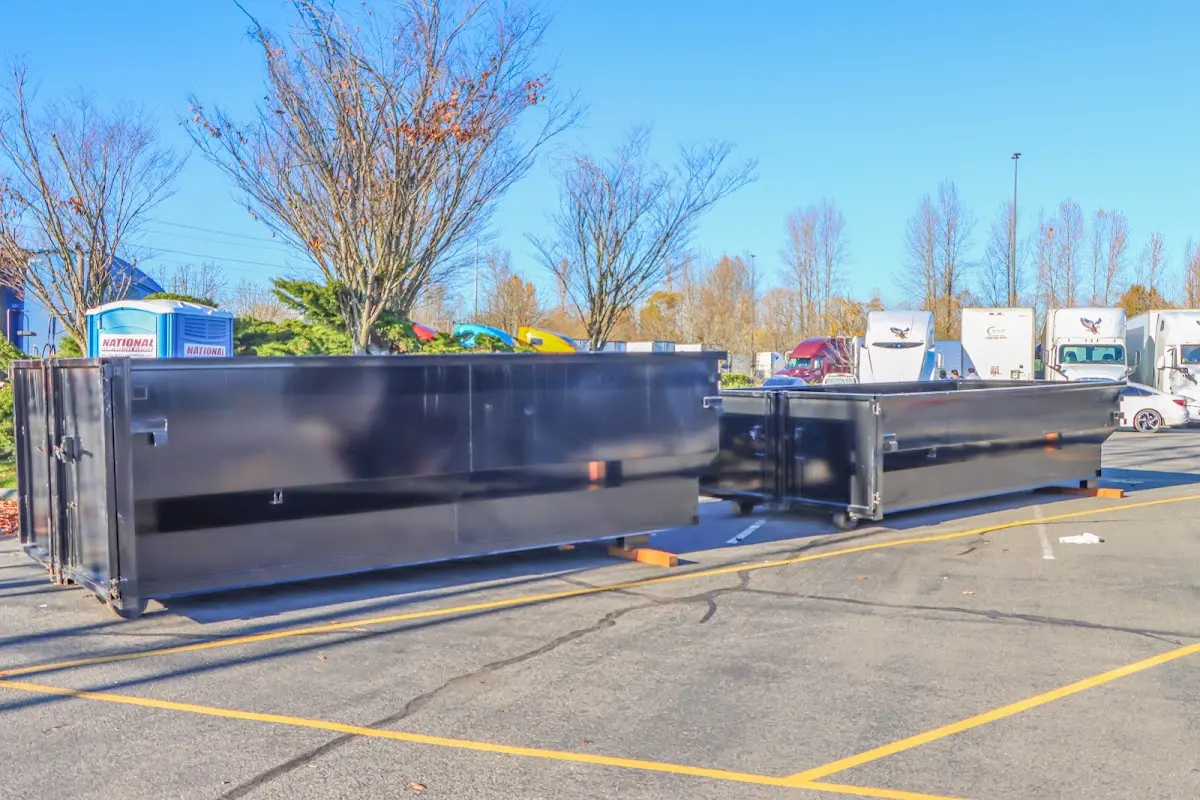 Professional dumpster rental service with roll-off container on residential driveway in Elsa
